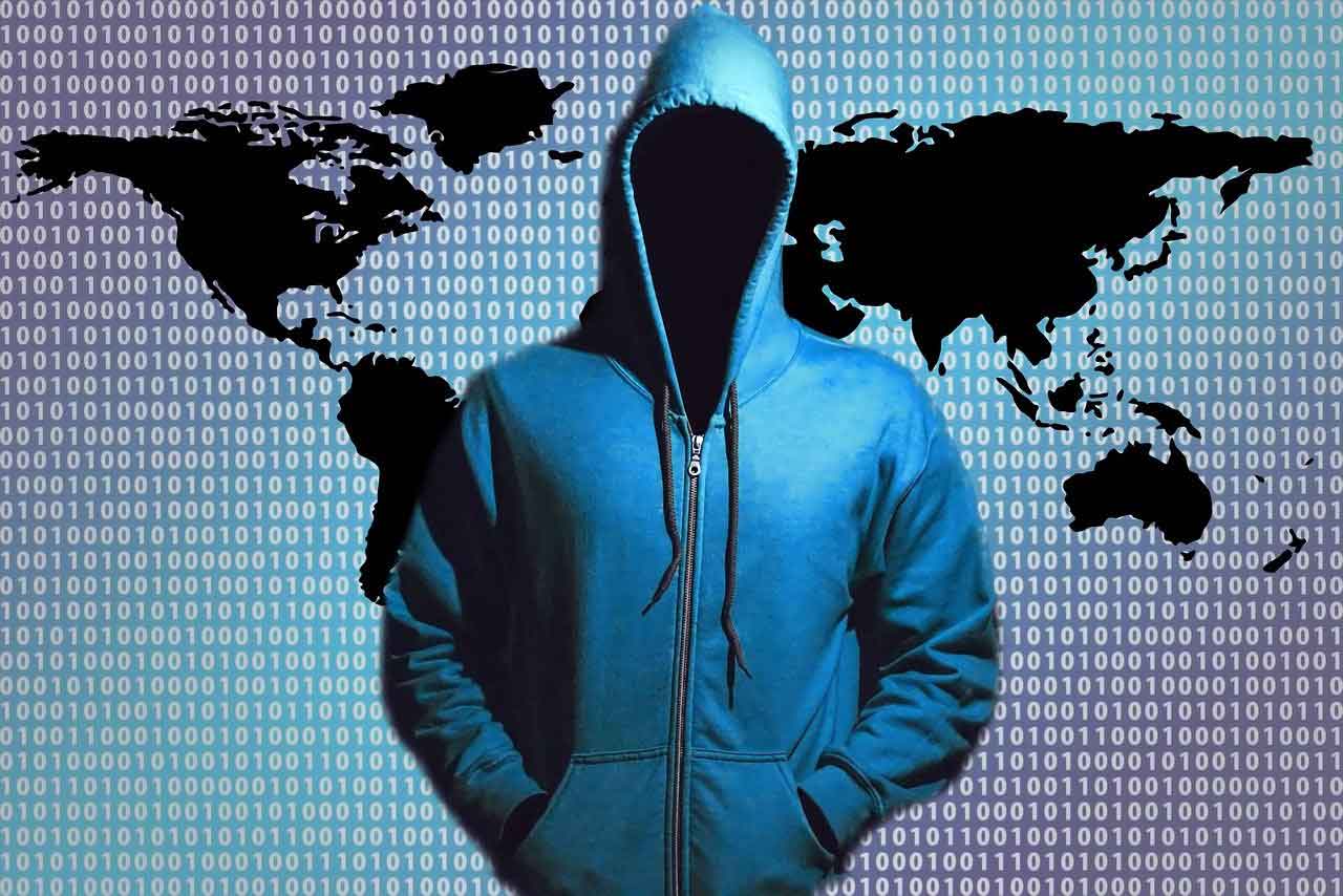 Hacker stands in front of world map in the background